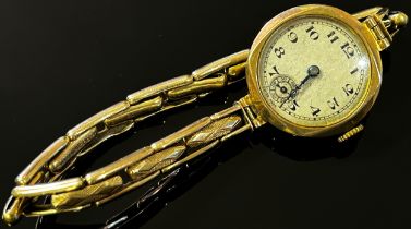 An early 20th century Swiss 9ct yellow gold cased wristwatch, the silvered dial with black Roman