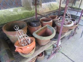 A quantity of weathered terracotta planters of varying size and design including a few examples with