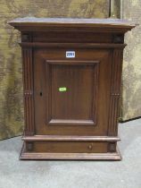 A small late Victorian mahogany hanging wall cupboard enclosed by a rectangular panelled over a