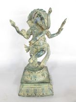 An Indian cast metal verdi gris finished statue of the elephant god Ganesh, raised on a round dais