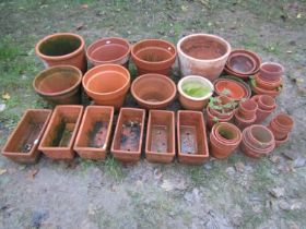 A quantity of weathered terracotta pots and planters of varying size and design