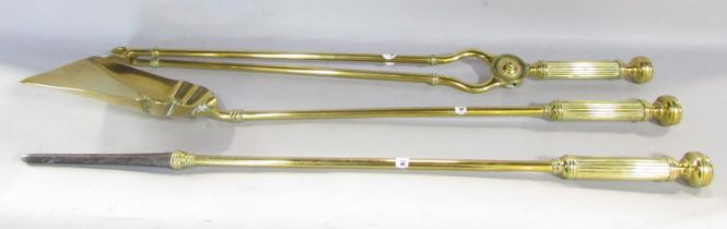 A set of three Victorian brass fire irons, poker, shovel and tongs, each with reeded handles