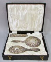 An early 20th century silk lined box with a silver hair brush set, a hand mirror, hair and clothes