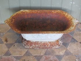 An old painted and weathered French cast iron planter of rectangular canted and tapered form with