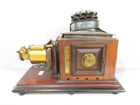 A Victorian Triumph Magic Lantern slide projector on a mahogany plinth.