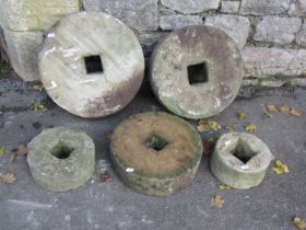 Five weathered mill stones of graduated size, the largest 45cm diameter, the smallest 20cm,