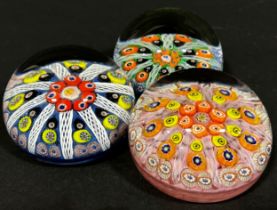 Three Millefiori multicoloured cane paperweights in the Monart style.