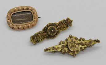 Three antique brooches; a 19th century yellow metal mourning brooch containing woven hair and two