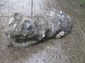 Novelty weathered cast composition stone recumbent pig, 50cm long x 19cm high (af)