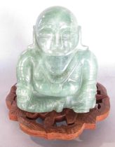 Green stone (poss aventurine) Ho Tai seated buddha on carved stand with leaf motif (20th century)