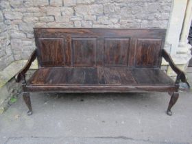 A Georgian oak bench with rectangular fielded panelled back, open downswept arms raised on