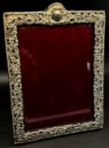 A silver portrait photo frame with scrolling detail, red leather covered back stand, 10 x 14 cm