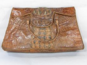 A crudely made crocodile skin bag with a division to interior 54cm wide x 34cm approx.