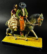 A ceramic figure group in the form of a couple open horseback, ‘Flamencos A Caballo’, with hand