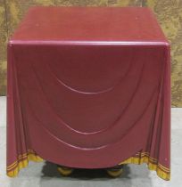 A square cut occasional table in the form of a cloth draped table with maroon and gilded fringe,