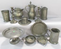 A varied selection of early 19th century pewter table ware, including tankards, jugs, a pair of