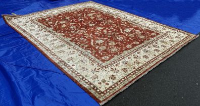 A Ziegler carpet with an all over floral pattern on a red ground with running floral borders, 323