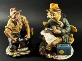 Three Capodimonte figures, a man at an anvil, reading a newspaper and feeding a cat (3)