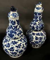 A pair of 19th century Chinese gourd shaped blue and white porcelain vases and covers with