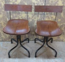 A pair of vintage style industrial work chairs on swivel bases with dished oak seats and backs