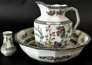 A Cauldon ware ewer and basin and accompanying toothpaste jar, with floral detail in a polychrome