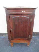 Georgian oak hanging corner cupboard enclosed by an arched and panelled door within reeded corners