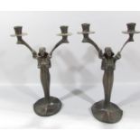 A Pair of bronze Art Nouveau candlesticks of women holding two candle branches, both bearing the