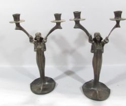 A Pair of bronze Art Nouveau candlesticks of women holding two candle branches, both bearing the