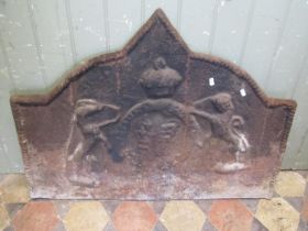 A cast iron fire back of stepped arched form with raised relief armorial detail 69 cm high x 89 cm