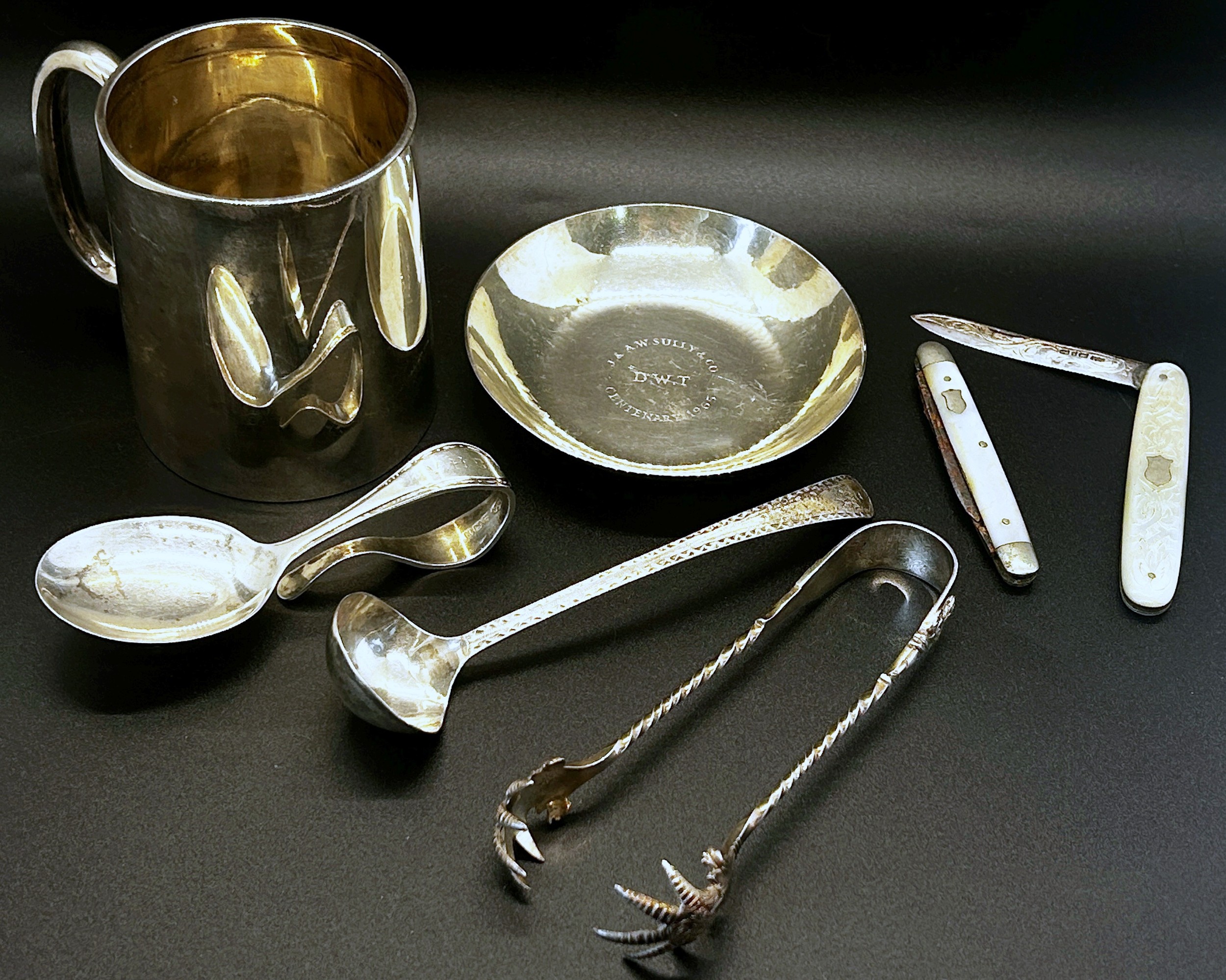 A mixed collection of silver items to include pen tray, christening mug, a centenary dish, a sauce