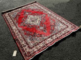 North West Persian Sarouk Rug with a central floral elongated medallion on a predominantly red