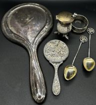 A quantity of silver including a hand mirror, napkin ring, two souvenir spoons, thistle salt pot and