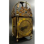 An antique lantern clock of traditional form, the brass dial with engraved detail, with chased inner