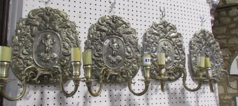 Four 18th century continental style wall sconces decorated with cherubs and foliate scrolling each