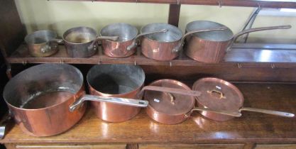 A collection of nine graduated heavy copper saucepans with steel handles by Elkington & Co and