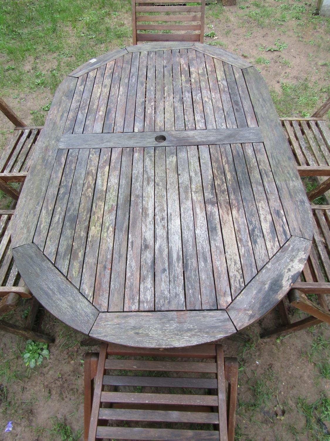 A weathered contemporary teak garden table of oval form with slatted top, raised on X framed - Image 2 of 9