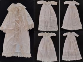 Five early 20th century baby garments including a cream woollen carry shawl with embroidered yoke