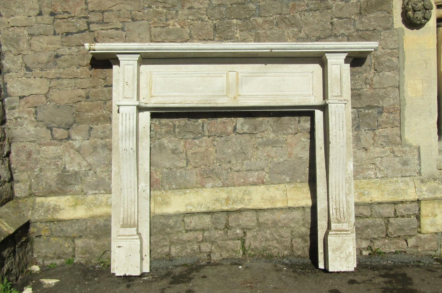 A late Victorian/Edwardian painted wooden fire surround with fielded panelled back and swept