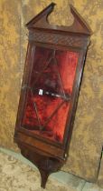 An Edwardian rosewood hanging corner cabinet in the Georgian style, with broken architectural arched