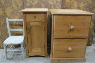 A continental stripped pine bedside cupboard with rectangular panelled door and frieze drawer,