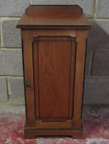 A late Victorian walnut and ebonised banded bedside cupboard enclosed by a rectangular panelled