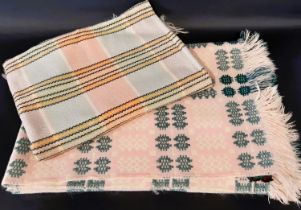 A traditional woollen Welsh blanket of reversible double weave in pink, green, white and cream