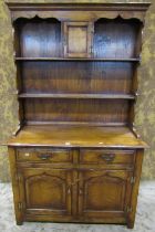 A good quality reproduction oak cottage dresser with distressed finish, the base enclosed by a