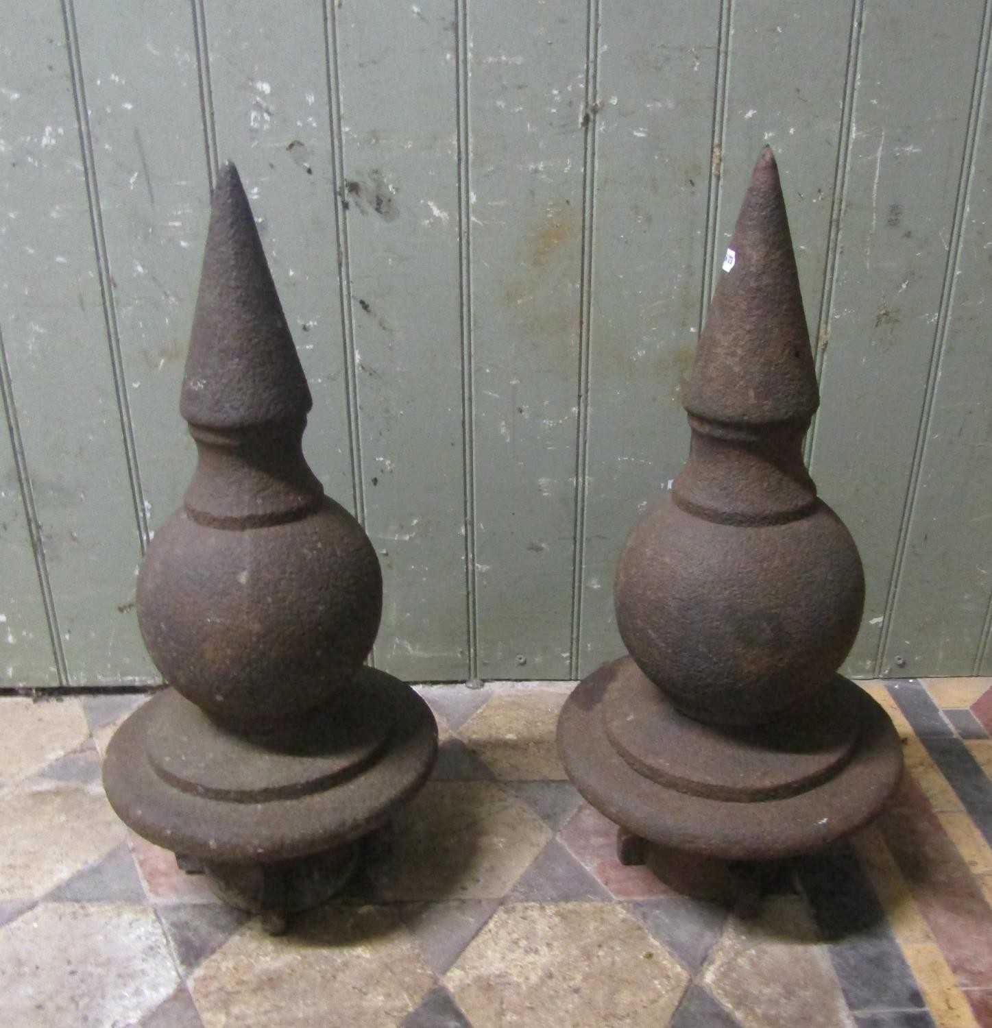 A pair of weathered cast iron gate post finials 51 cm high