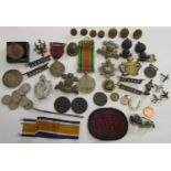 A box of regimental cap badges, defence medal, ARP badges etc