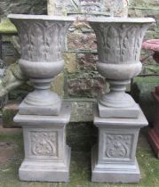 A pair of cast composition stone trumpet shaped vases with repeating acanthus leaf detail and