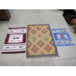 A Kilim carpet with diagonal trellis pattern, 150cm x 98cm and two kilim type mats 125cm x 72cm,