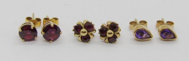 Three pairs of 9ct gem set stud earrings; a pear-cut amethyst pair and two garnet pairs, 4.1g