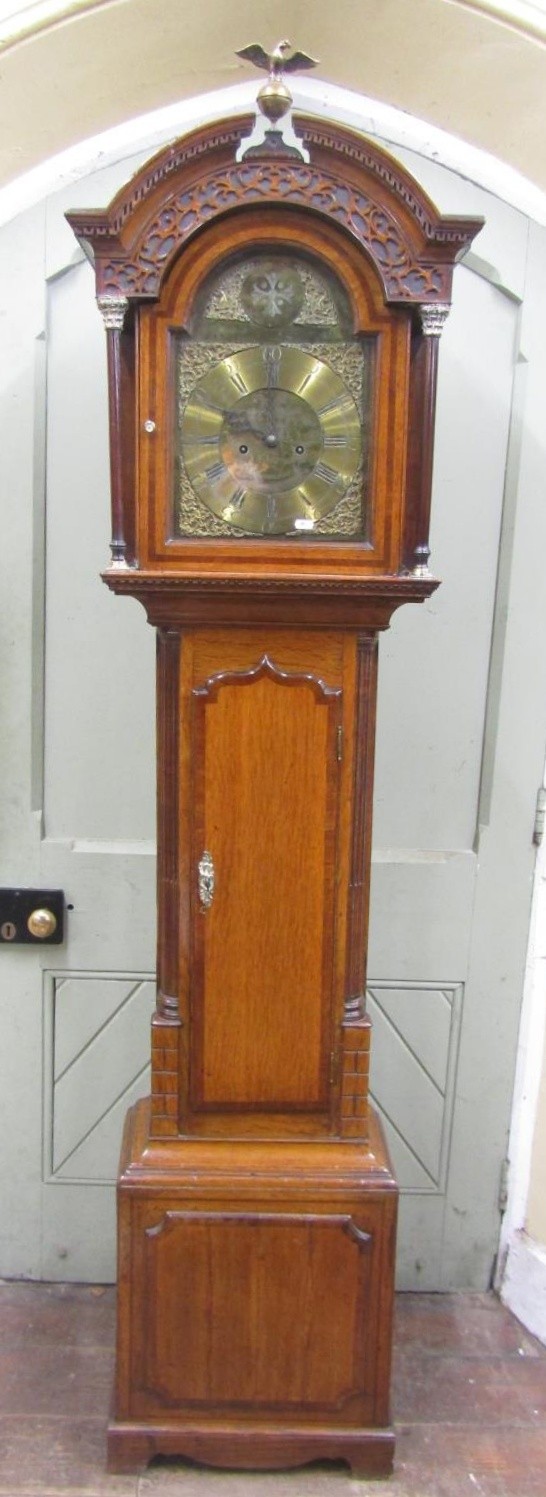 A Georgian oak longcase clock, the trunk crossbanded in walnut and with reeded column supports,