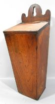 A 19th century elm candle box with a sound hinge with a selection of modern candles, 42 cm high.